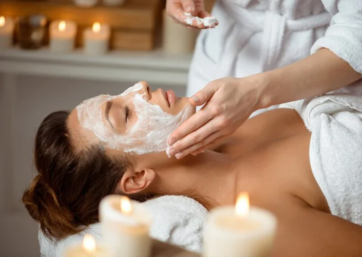 a woman lying down with a white mask on her face