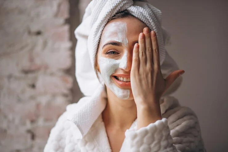 a woman with a white towel on her head and a white towel on her head covering her face with a white mask on her face